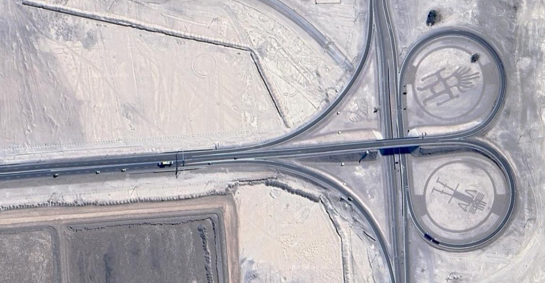 a satellite image of an overpass with geoglyphs within the slip lane circles